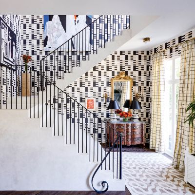 Black and white graphic wallpaper covers walls around a staircase.
