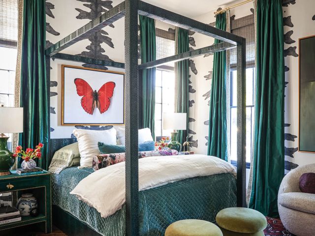 A butterfly painting hangs over a black and teal bed in a room with zebra wallpaper.
