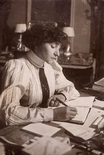 Colette at a desk writing in a journal.