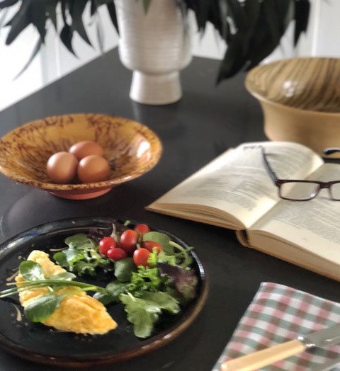 omelet on a table with a book and reading glasses
