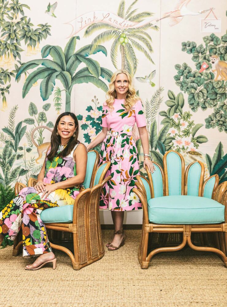 Roxy Owens and Sarah Wetenhall are side by side in front of a tropical mural.