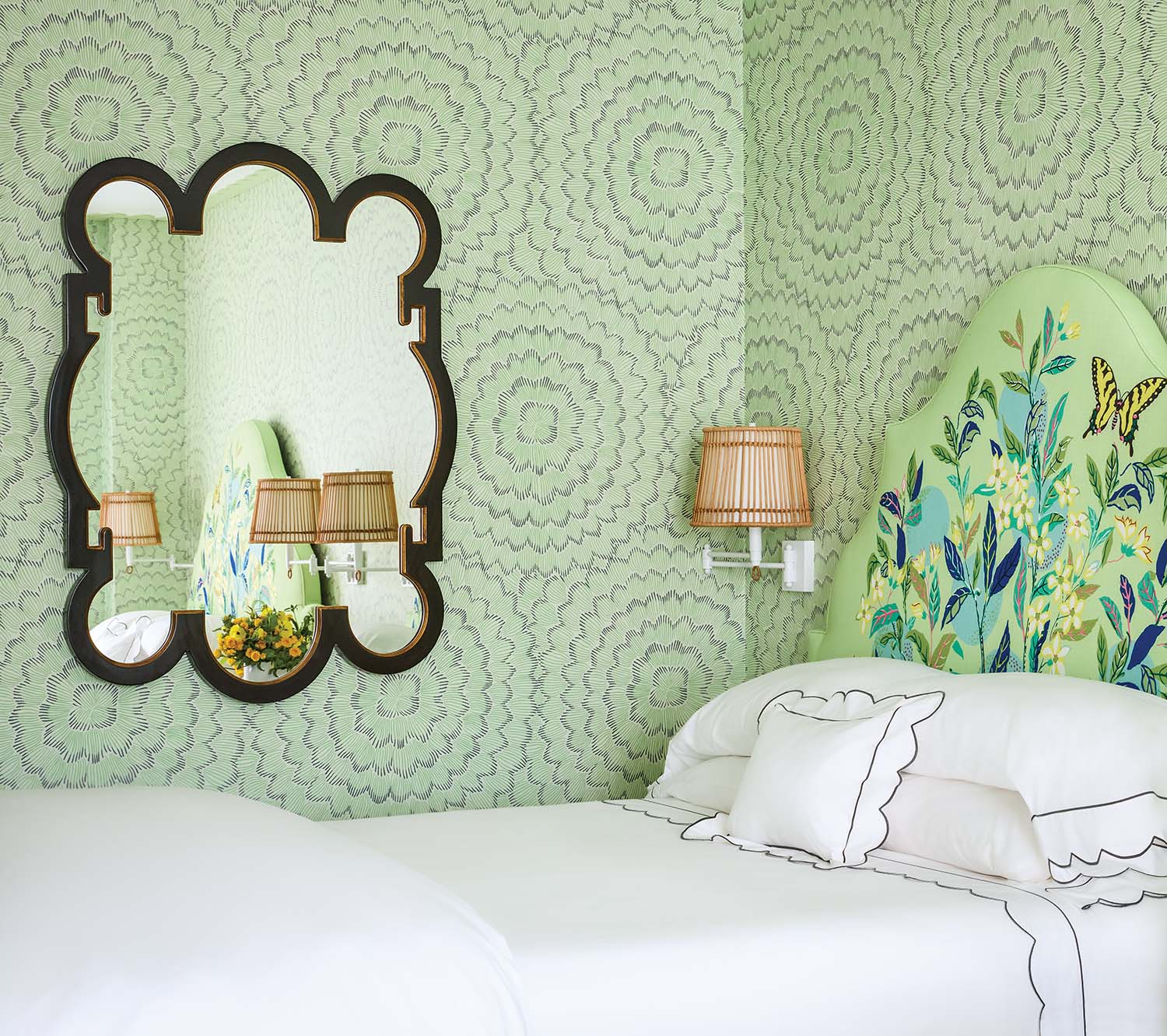 Swirling green wallpaper envelopes a hotel room with a crisp clean bed.