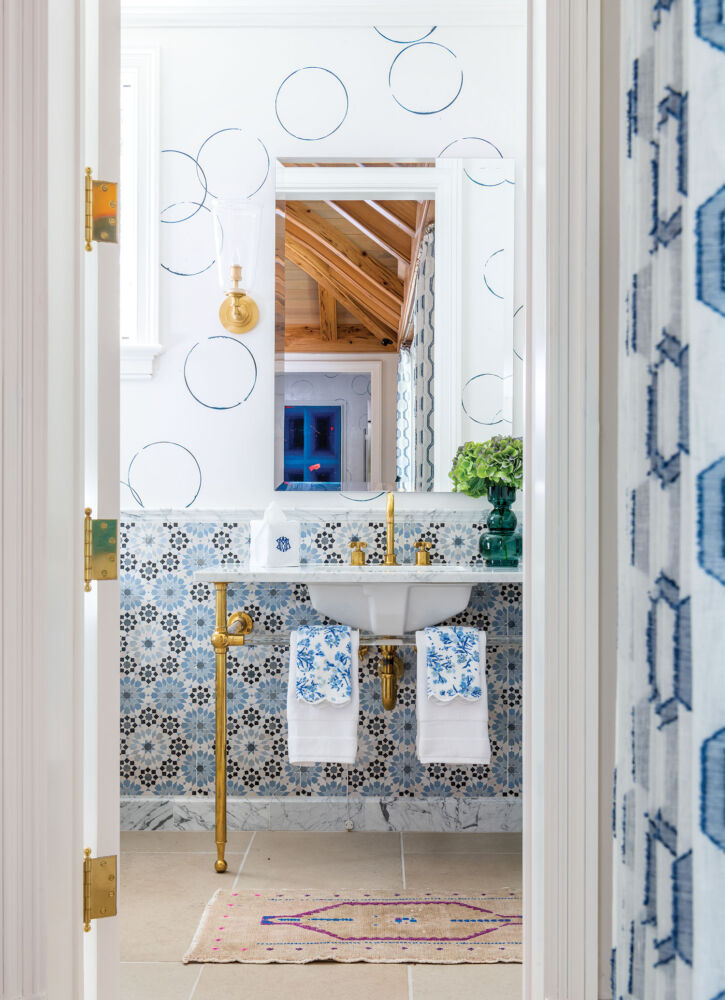 A blue mosaic tile covers the bottom half of a bright bathroom.