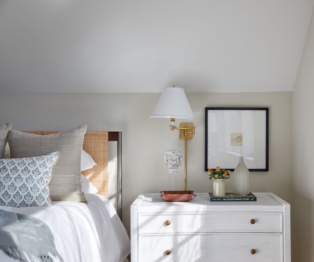 Using swing arm lamps is a great way to free up beside table space to create a vingnette and include artwork like this bright bedroom by Angela Hamwey of Mackenzie & Co.