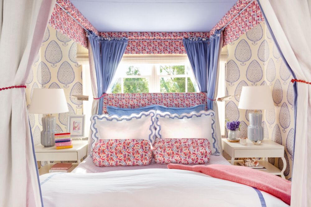 In a snug wallpapered bedroom with red, white, and blue bed hangings, Nashville designer Blaire Murfree chose a combination of table and swing arm lamps for versatility.