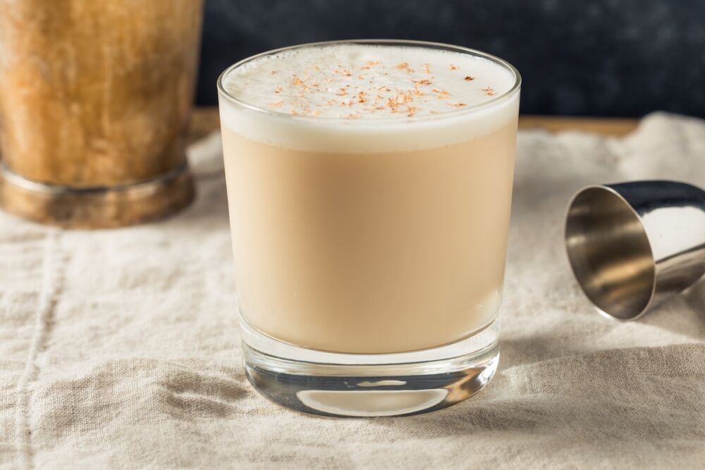 Glass of brandy milk punch topped with grated nutmeg.