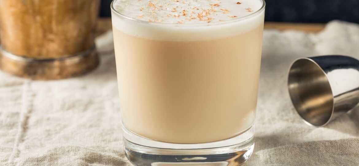 Glass of brandy milk punch topped with grated nutmeg.