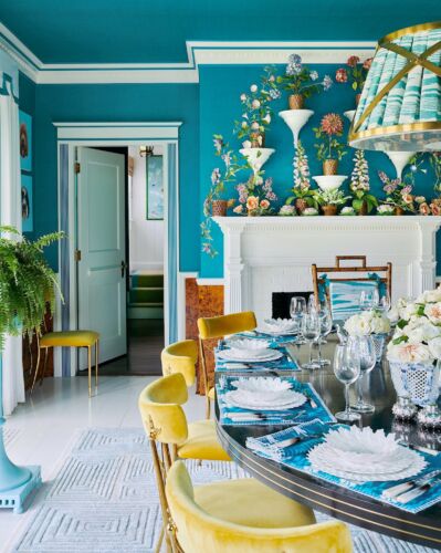 Liz Lange covered the walls and ceilings of her dining room in a vibrant turquoise and contrasted that with yellow velvet mid century chairs.