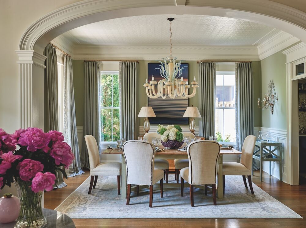 Dining room using Chippendale chairs and the Piedmont table from Hickory Chair. The curtain fabric is by Romo; the antique rug was sourced through Moattar; and the light fixture is an antique Murano glass chandelier.
