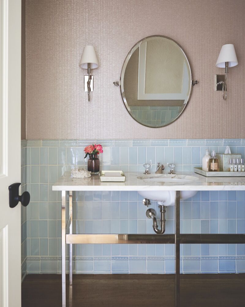 Bathroom with blue tile and Cowtan & Tout wallcovering and Visual Comfort & Co. sconces to refine the look and feel of the space.