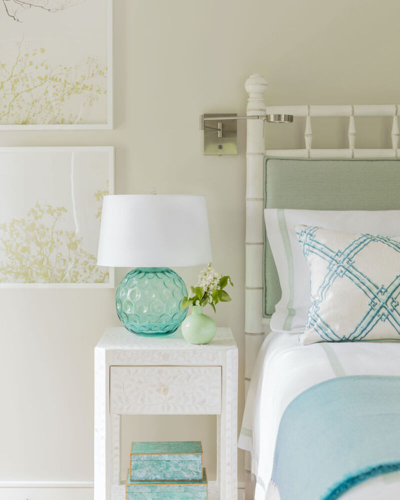 In a light and bright coastal-feeling bedroom, Robin Gannon included dimpled glass lamps with chrome swing arms, a favorite pairing of designers.