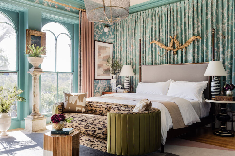 A very posh bedroom by Boston area designer Robin Gannon includes a wall of drapery and three types of lighting: a mesh-like chandelier, ceramic table lamps, and sconces attached to the wallpaper.