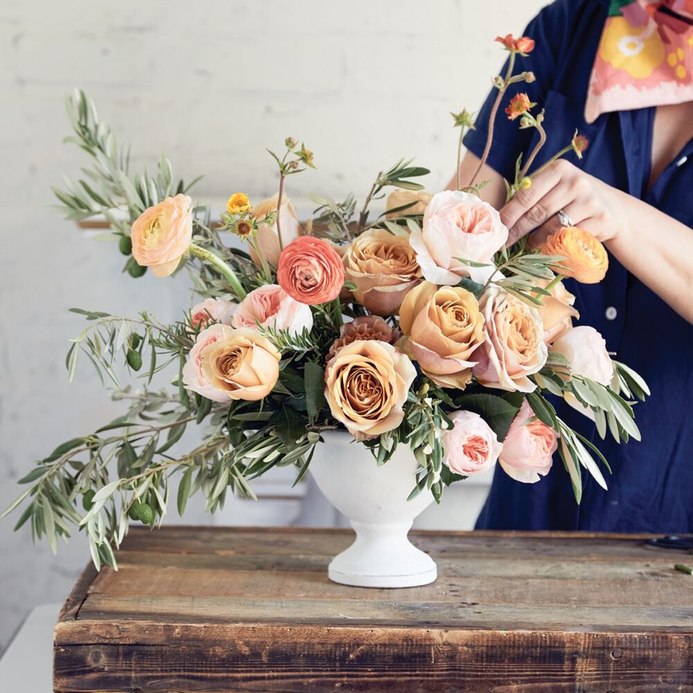 Florist adds geum flowers to Tuscan inspired floral arrangement.