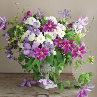 Purple flower arrangement featuring clematis, California lilacs, ‘Gourmet Popcorn’ roses, and atriplex branches by Kate Holt