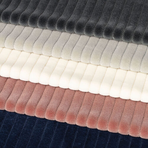 samples of wide corduroy fabrics in navy, muted coral, off-white, tan, and gray