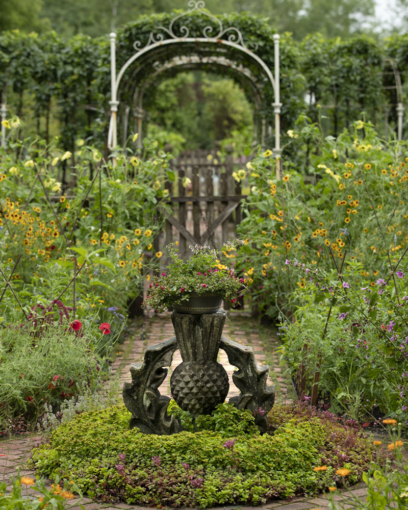 Caption from the book Gardens of the North Shore of Chicago: “An eighteenth-century Scottish thistle finial sits in a bed of sedums in a cutting garden of heirloom annuals and herbs. An antique wrought-iron arbor, found in an Oxford University courtyard, connects to a second cutting garden.” (Kelton House Farm in Fredonia, Wisconsin)