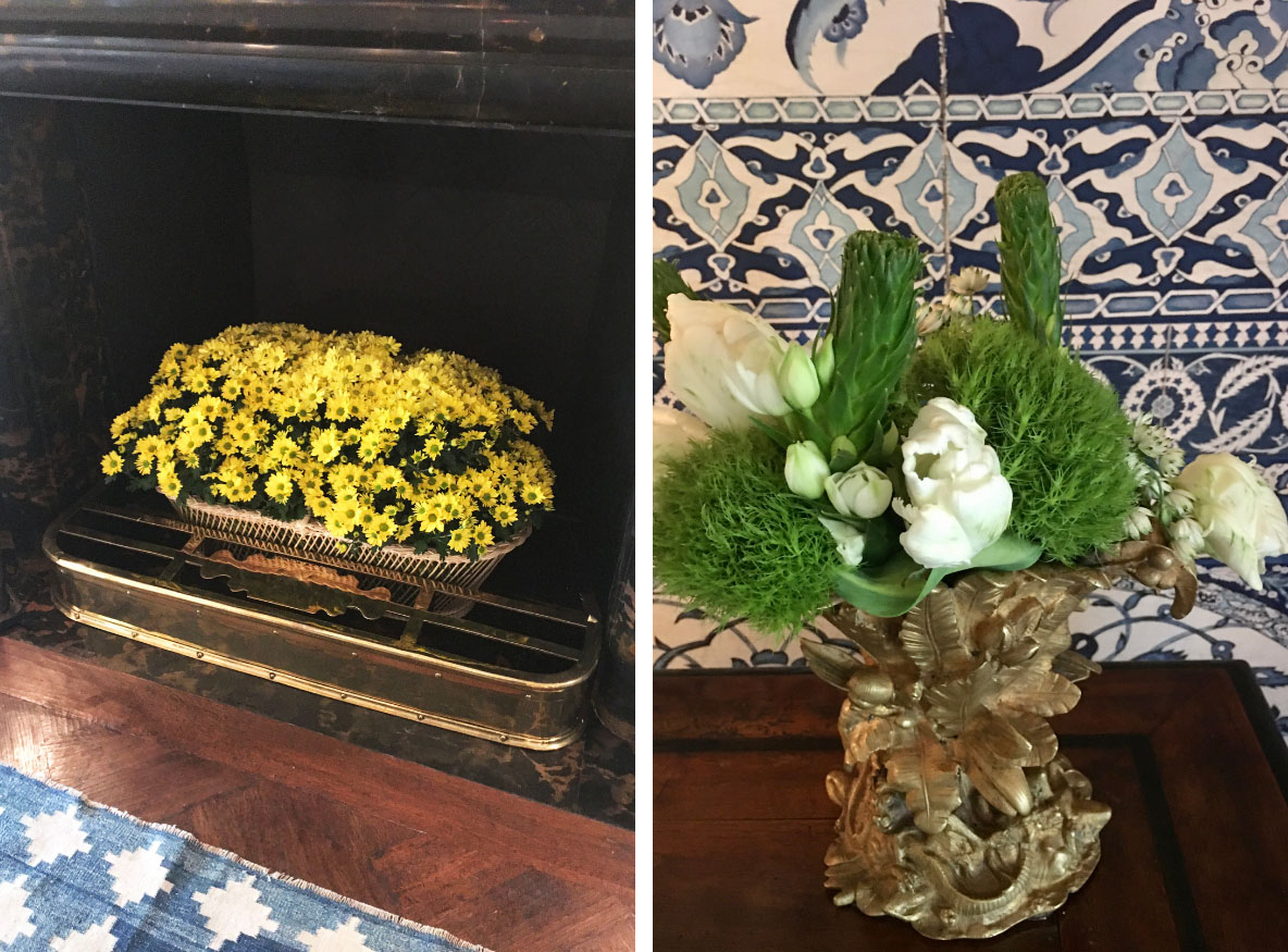 (left) a basket of potted yellow mums fills a fireplace. (right) a simple green and white floral arrangement in an antique brass vase with intricate botanical details