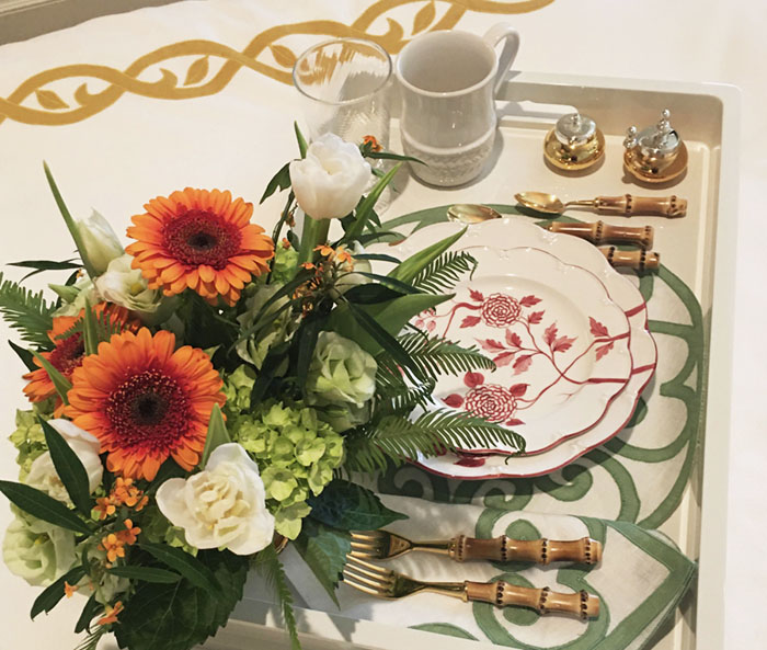 breakfast tray on bed, styled with flowers and place setting