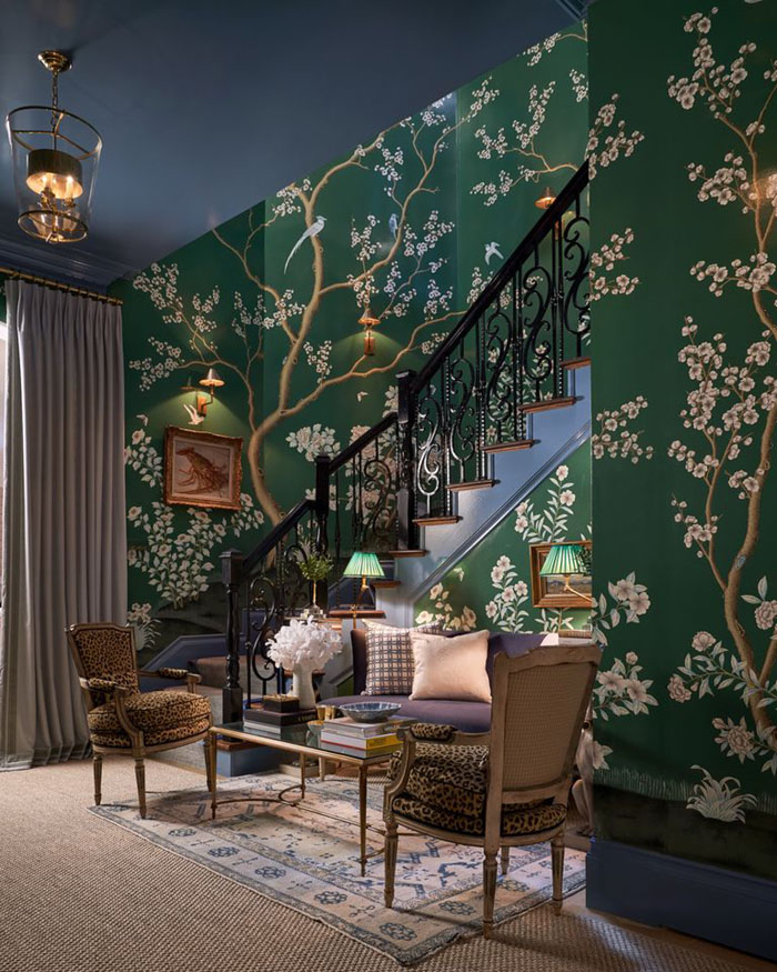 A staircase in a room wallpapered in a floral print with dark green background in the Kibs Bay Dallas showhouse 2020