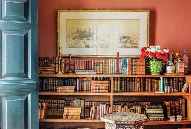 home library with terra-cotta-colored walls and a dusky blue door leading outside