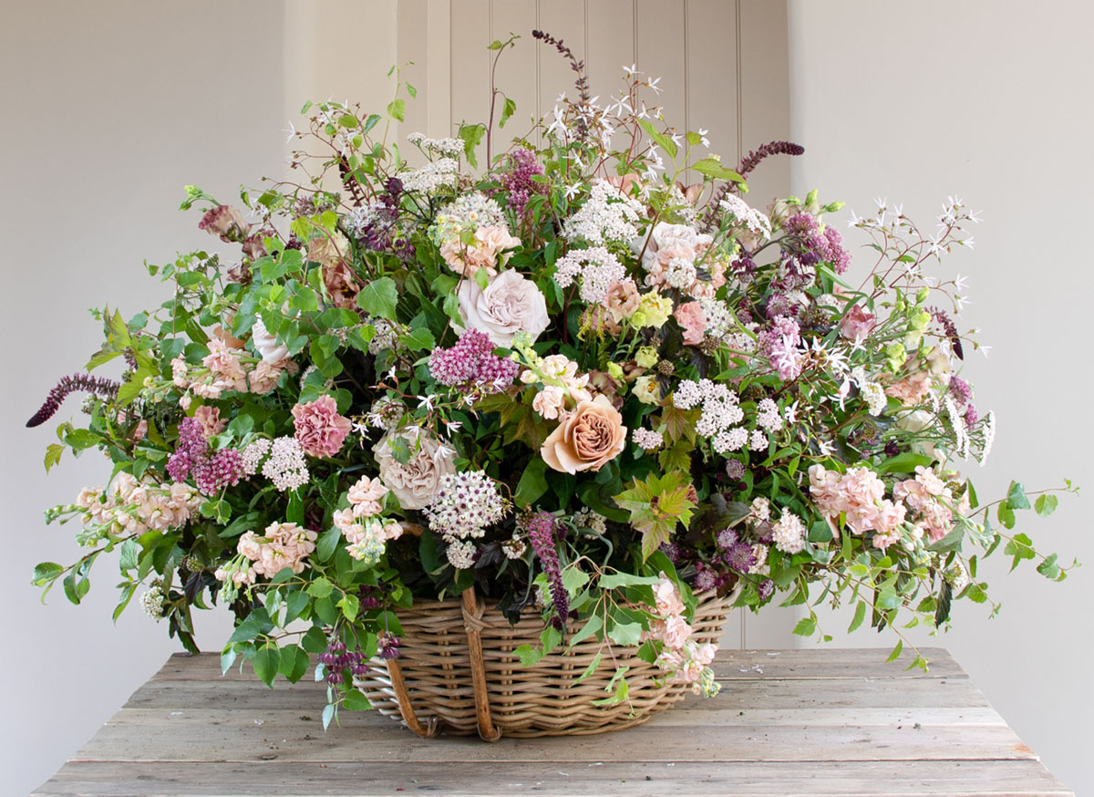 large garden style arrangement in a basket by British floral designer Philippa Craddock