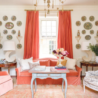 living room designed by Janie Molster, velvet sofa and club chair, plate hanging, coral color decor scheme