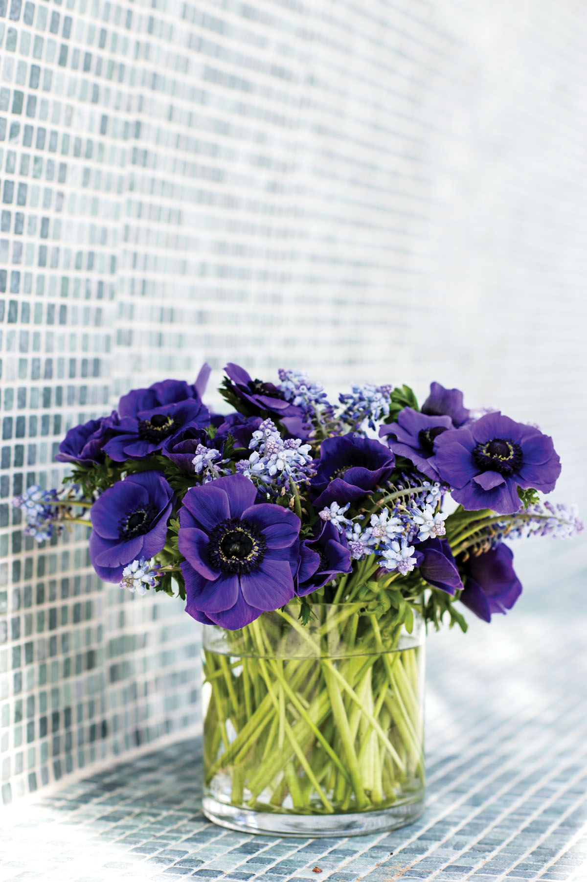 purple flower arrangements set on a blue-green tile mosaic
