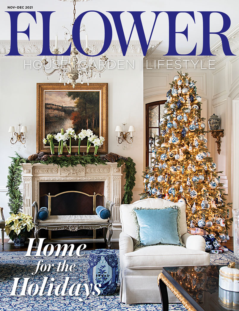 November December 2021 cover of Flower magazine featuring a Christmas tree and mantel decorated with a garland and potted amaryllis flowers in the blue-and-white living room of Tina Yaraghi, founder of The Enchanted Home