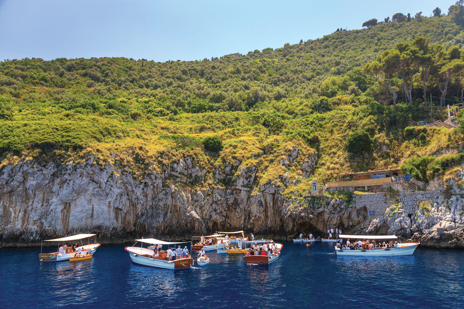 2F762GN Tourists waiting to enter the Blue Grotto (Grotta Azzurra) by rowing boat on the Island of Capri, Italy, Amalfi Coast