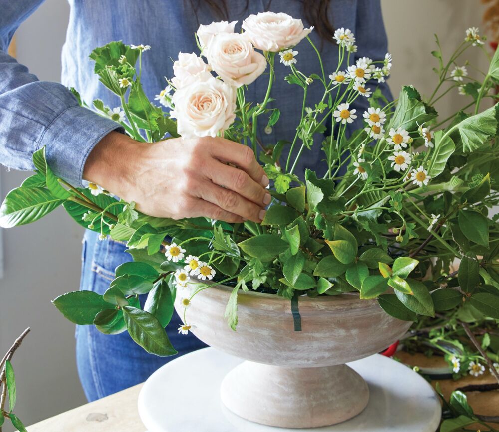 adding feverfew and spray roses to arrangement