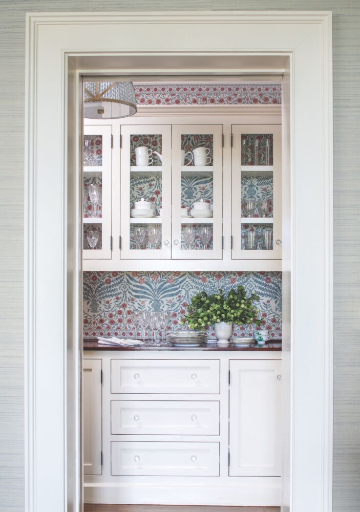 Butler's pantry with Lee Jofa’s Sameera wallpaper on backsplash and in cabinet.
