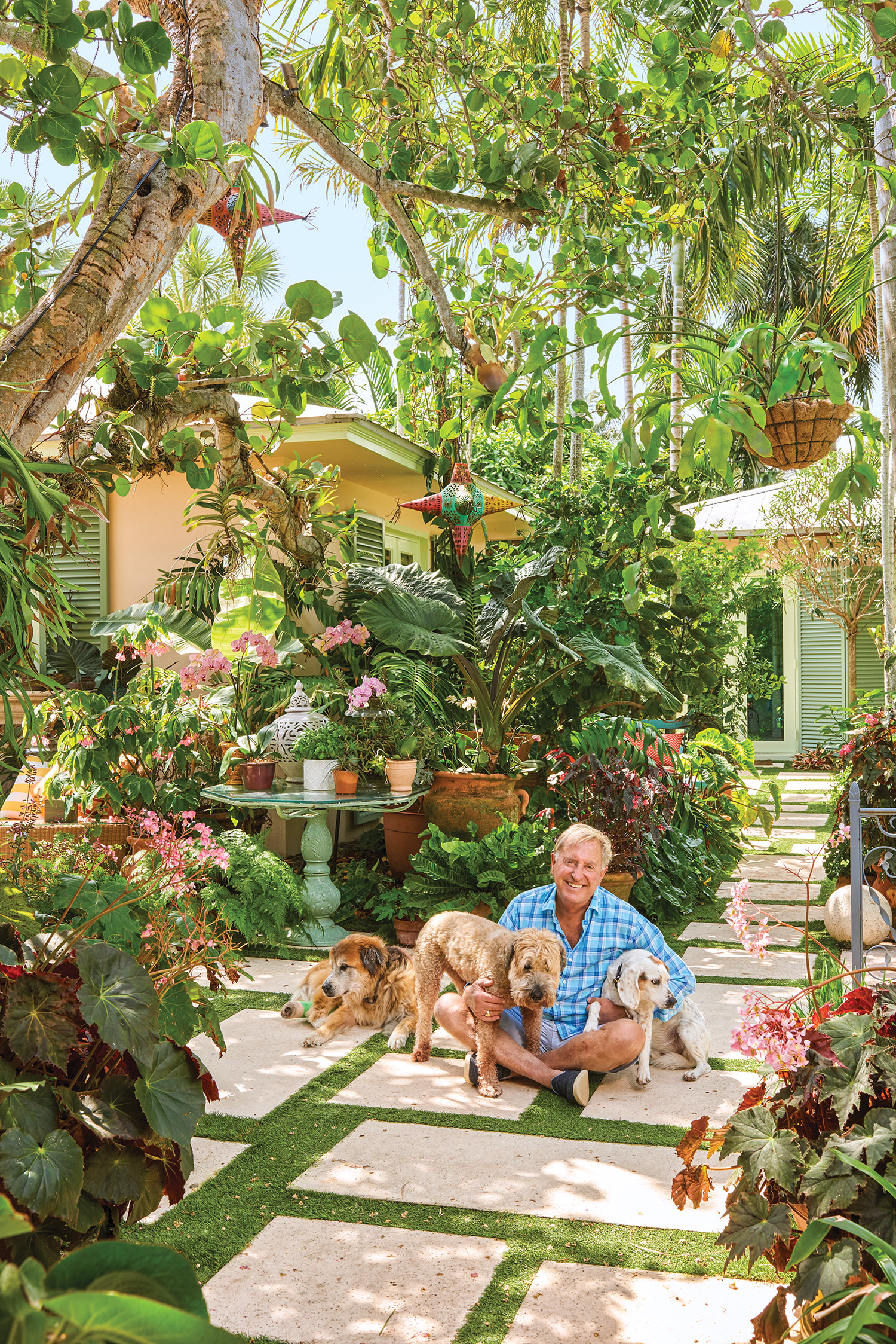 Renny Williams with dogs in his tropical garden