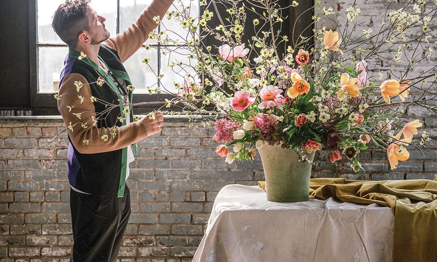 designer arranging flowers in floral workshop