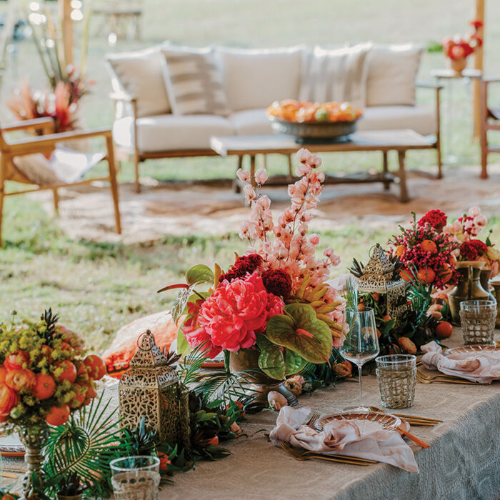 A tablescape of peonies, ranunculus, and citrus fruits at Camp Round Top