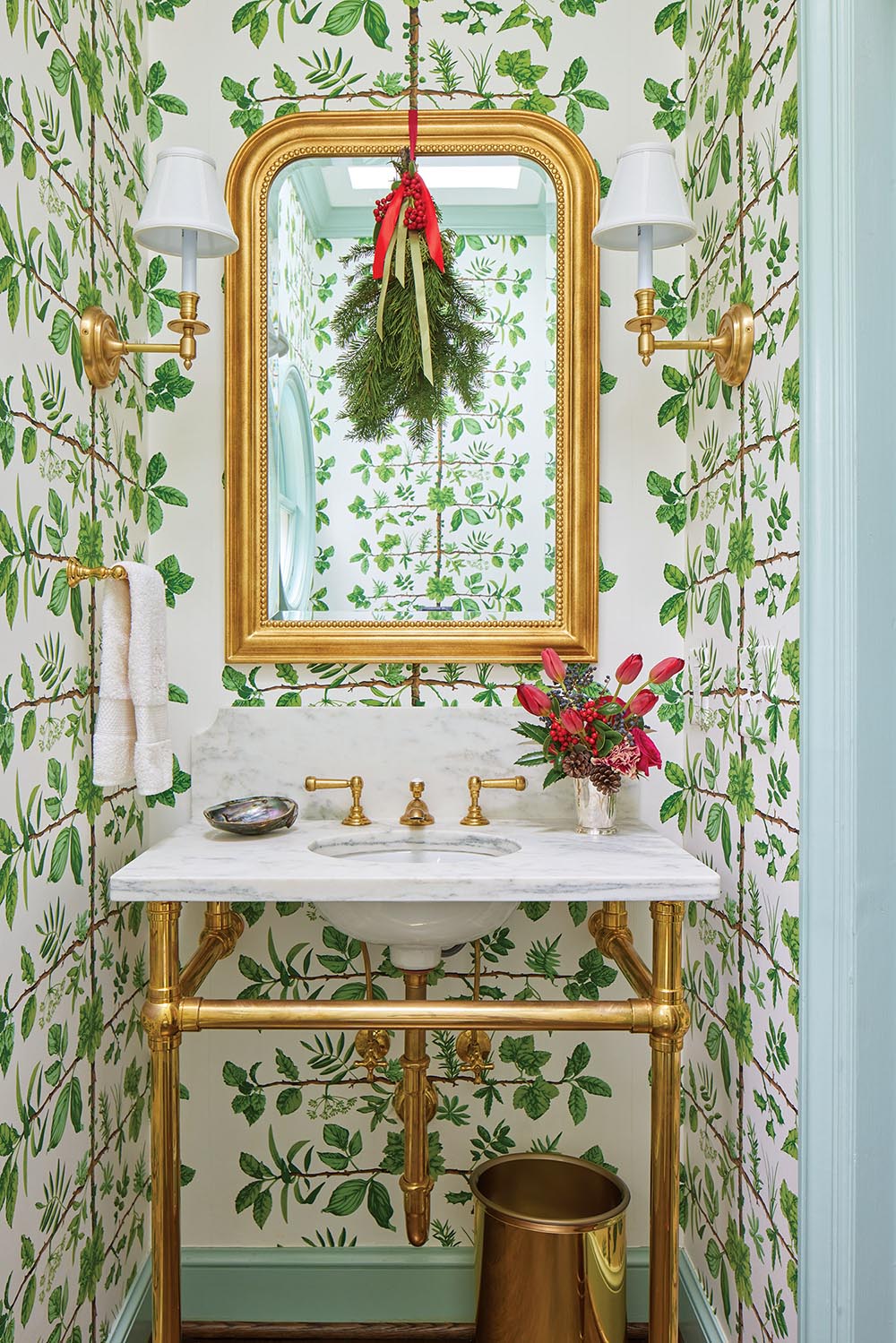 Powder room bathroom decorated with green and white wallpaper and holiday greenery
