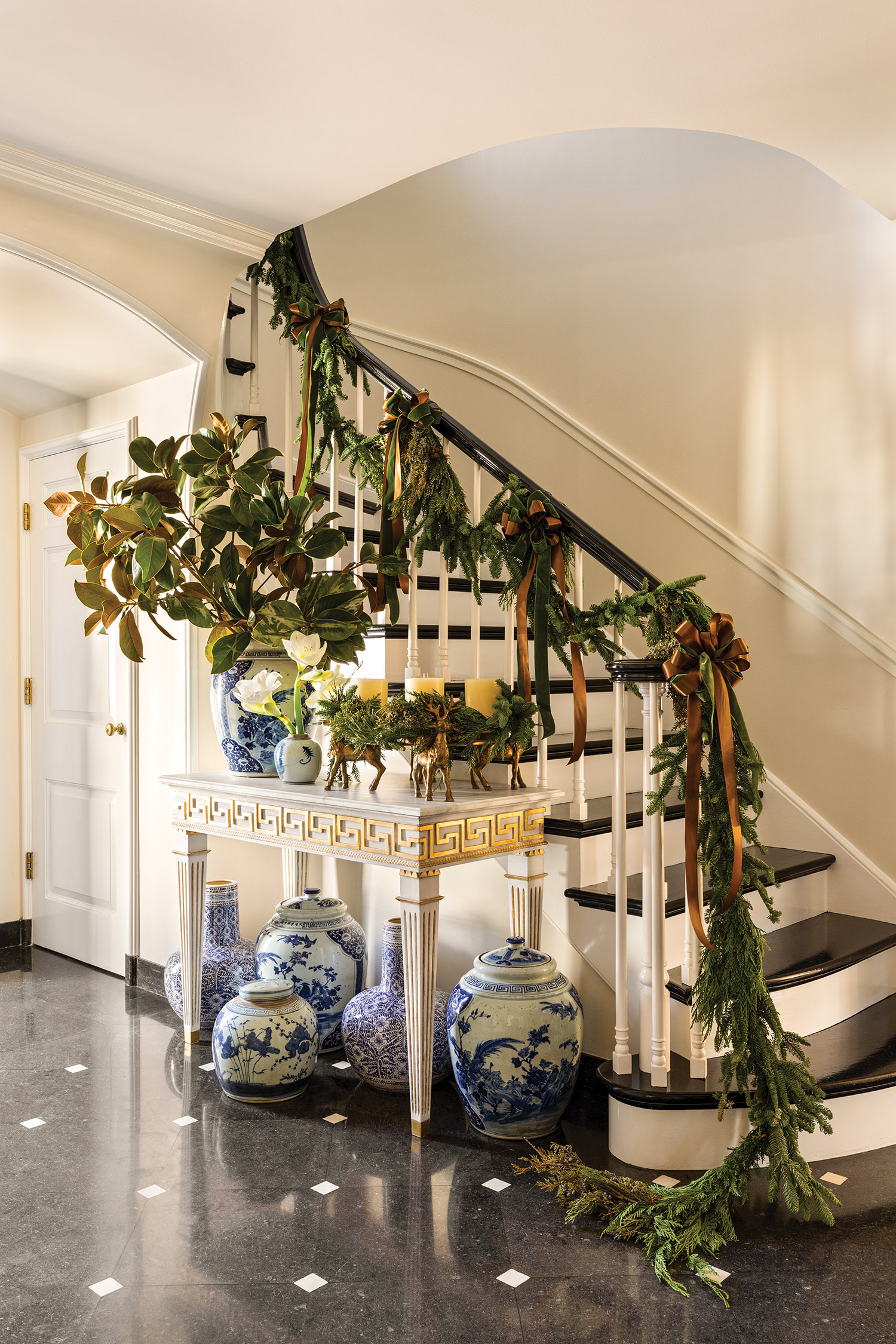 foyer decorated with blue and white ginger jars and garland