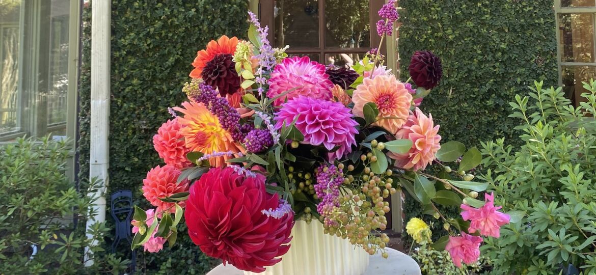 Lewis Miller arrangement of dahlias and foraged camellias, beautyberry, and Russian sage.