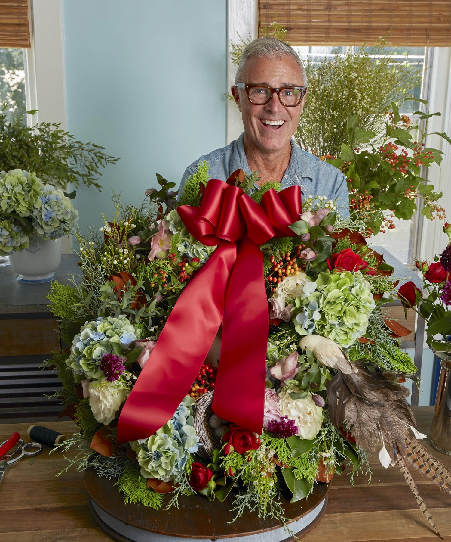 Michael Giannelli with Christmas wreath showing its red ribbon bow.