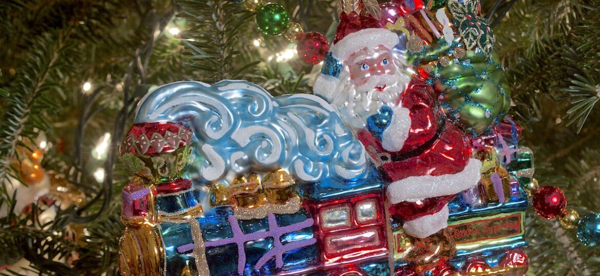 Glass Christmas ornament with Santa riding steam train.