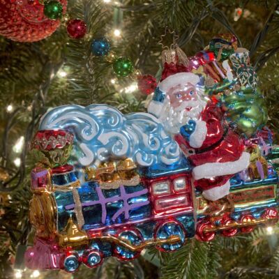 Glass Christmas ornament with Santa riding steam train.