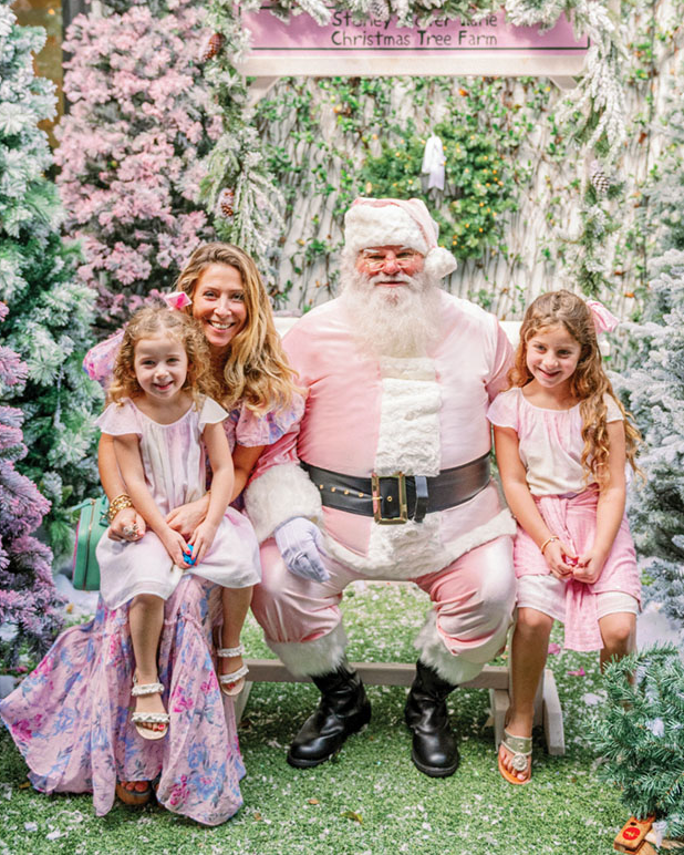 Santa dressed in pink with mom an two daughters at party