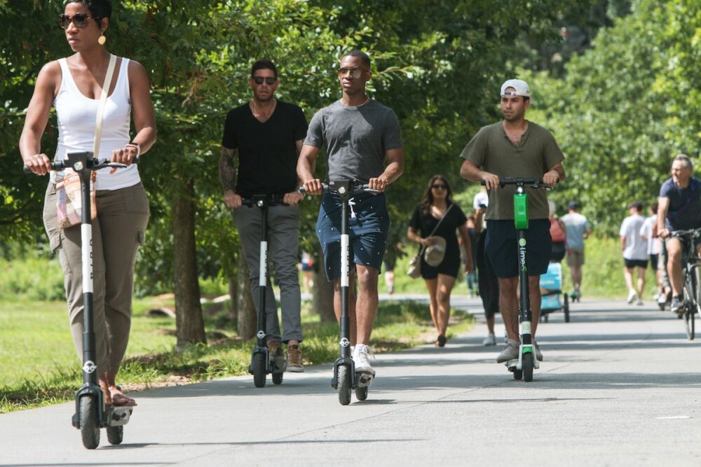 People riding scooters and walking on the BeltLine near the Old Fourth Ward