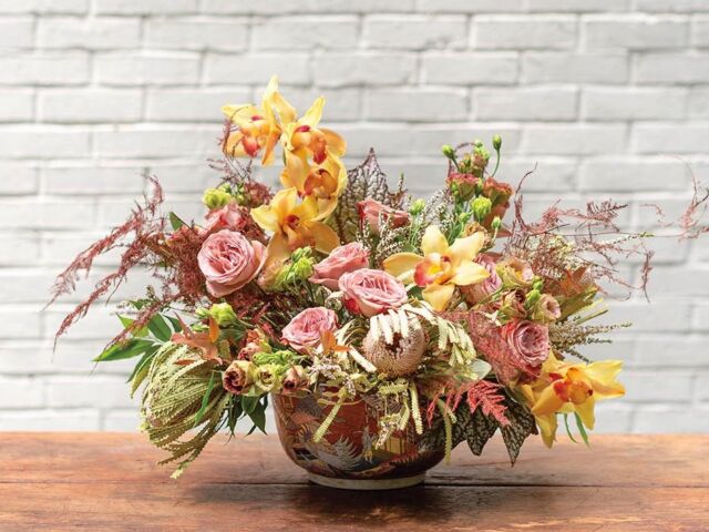 Arrangement of pink roses, yellow cymbidium orchids and other flowers inspired by a painting at the Flower Atlanta Showhouse
