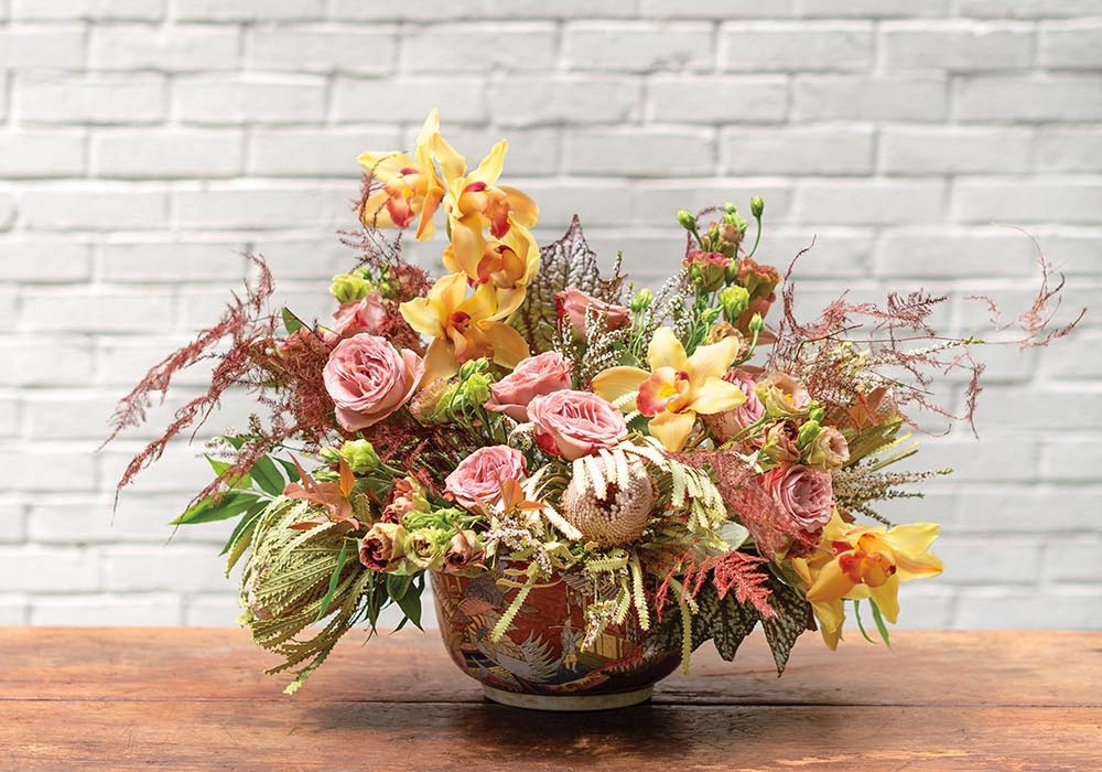 Arrangement of pink roses, yellow cymbidium orchids and other flowers inspired by a painting at the Flower Atlanta Showhouse