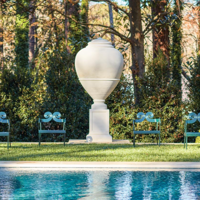 Oversized casting of an Italian olive jar behind the swimming pool in a garden designed by John Howard.
