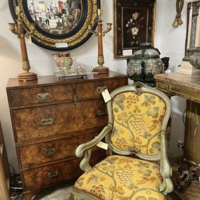 Antique yellow chair, wooden chest, round mirror in Peachtree Battle Antiques