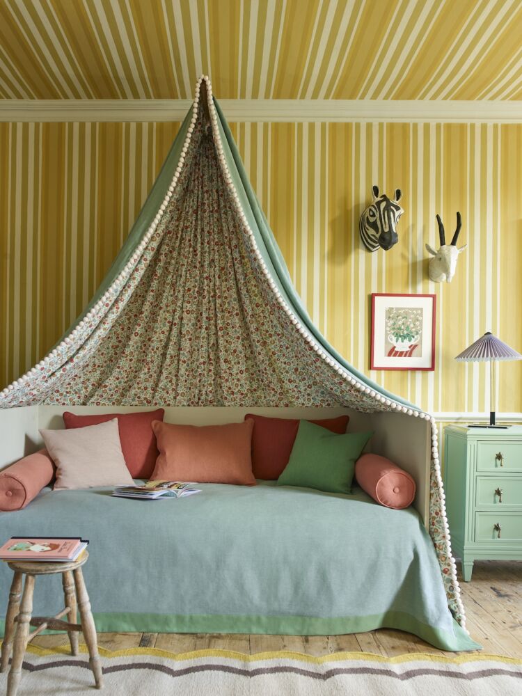 Child's bedroom with canopy over daybed and Liberty Obi Stripe wallpaper in Fennel on wall and ceiling.
