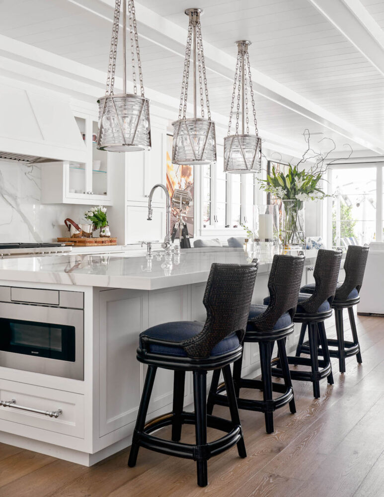 Kitchen with the hardware and plumbing fixtures in chrome paired with chrome and glass pendants.