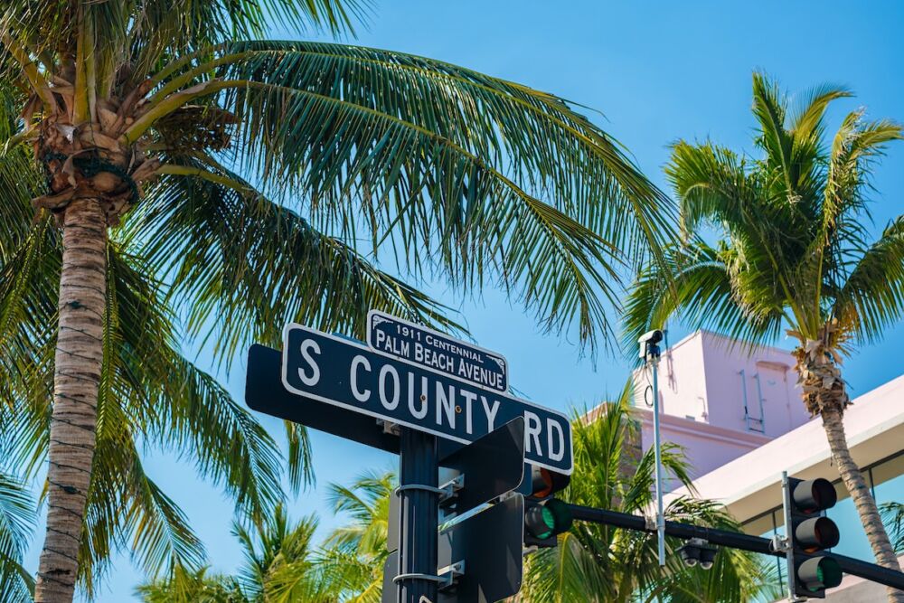 S County Road street sign with palm trees in Palm Beach, Florida.