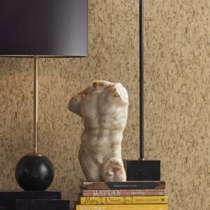 Tabletop vignette with Greek torso atop stack of books. Lamps with black shades on table.